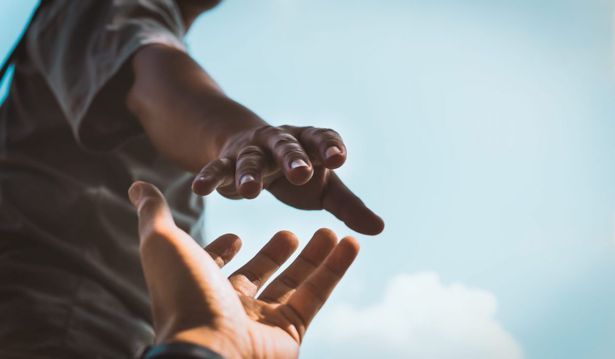 Help Concept hands reaching out to help each other in dark tone